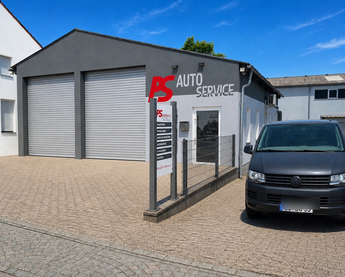PS Autoservice, Werkstattgebäude mit Rolltoren und Eingangsschild in Landau in der Pfalz