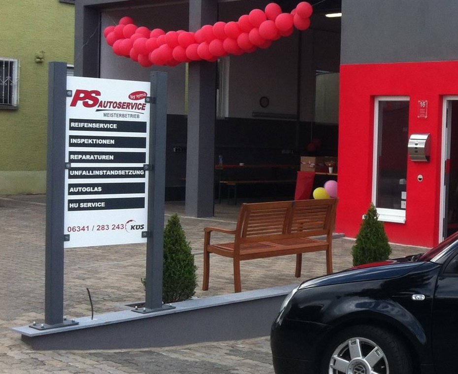 Eingangsbereich und Schild von PS Autoservice mit Leistungsliste und Telefonnummer